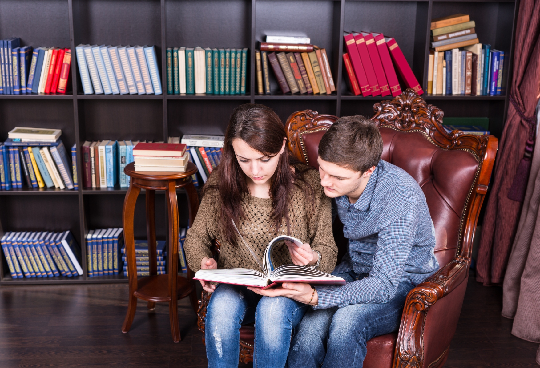 kozzi-Serious_Young_Couple_on_a_Chair_Reading_a_Book-1755x1195-1.jpg